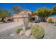 Charming home featuring a three-car garage, desert landscaping and a cozy front patio seating area at 10490 E Dreyfus E Ave, Scottsdale, AZ 85260