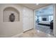 Hallway with neutral colored walls, tile flooring, and a view to the spacious main bedroom at 10490 E Dreyfus E Ave, Scottsdale, AZ 85260