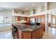 Kitchen featuring a spacious granite island, stainless steel appliances, and custom wood cabinetry at 10490 E Dreyfus E Ave, Scottsdale, AZ 85260