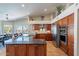 Spacious kitchen featuring granite countertops, stainless steel appliances, an island, and views of the backyard pool at 10490 E Dreyfus E Ave, Scottsdale, AZ 85260