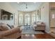 Bright living room with hardwood floors, arched windows with shutters, and a TV at 10490 E Dreyfus E Ave, Scottsdale, AZ 85260