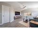 Cozy living room featuring modern entertainment center, ceiling fan, and beautiful gray wood laminate flooring at 10490 E Dreyfus E Ave, Scottsdale, AZ 85260