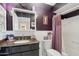 Charming bathroom with dark vanity, granite countertop, and decorative purple accents at 11011 N Coggins Dr, Sun City, AZ 85351