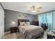 Stylish bedroom with a ceiling fan, decorative wall art, and neutral color palette at 11011 N Coggins Dr, Sun City, AZ 85351