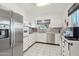 Well-lit kitchen featuring stainless steel appliances, white cabinetry, and tile flooring at 11011 N Coggins Dr, Sun City, AZ 85351