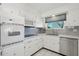 Bright kitchen with stainless steel dishwasher and oven, white cabinets, and updated countertops at 11011 N Coggins Dr, Sun City, AZ 85351
