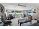 Bright living room featuring large windows with golf course views, comfortable seating and a stone fireplace feature at 11011 N Coggins Dr, Sun City, AZ 85351