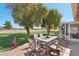 Charming patio with an outdoor dining set, lush foliage, and scenic golf course views at 11011 N Coggins Dr, Sun City, AZ 85351