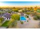 Aerial view showcasing the backyard pool, covered patio, and surrounding desert landscape at sunset at 11801 N Sundown Dr, Scottsdale, AZ 85260