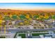 Aerial shot of the property showing desert landscaping, a green golf course, and mountain views at sunset at 11801 N Sundown Dr, Scottsdale, AZ 85260