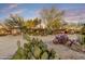 Desert landscaping surrounds a home with natural stone and stucco exterior under a colorful sunset at 11801 N Sundown Dr, Scottsdale, AZ 85260