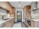 Modern kitchen with wood cabinets, stainless steel appliances, and views of the backyard through a glass door at 11801 N Sundown Dr, Scottsdale, AZ 85260