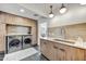 Modern laundry room with stainless steel appliances, light wood cabinets, and stylish lighting fixtures at 11801 N Sundown Dr, Scottsdale, AZ 85260