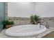 Close-up of a pristine white oval bathtub surrounded by decorative tiling at 120 E Rio Salado Pkwy # 101, Tempe, AZ 85281