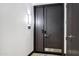 Stylish dark wood double front door with modern hardware, a security system, and a bright light fixture at 120 E Rio Salado Pkwy # 101, Tempe, AZ 85281