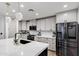 Stylish kitchen featuring a white island, gray cabinets, stainless steel appliances, and modern lighting fixtures at 120 E Rio Salado Pkwy # 101, Tempe, AZ 85281