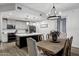 Bright kitchen and dining area featuring modern lighting, a dark island, and stainless steel appliances at 120 E Rio Salado Pkwy # 101, Tempe, AZ 85281