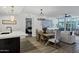 Open-concept living space with wood floors, a modern chandelier, and a dining table adjacent to the kitchen at 120 E Rio Salado Pkwy # 101, Tempe, AZ 85281