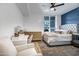 Bright main bedroom showcasing an upholstered bed, desk, and a chair by a window at 120 E Rio Salado Pkwy # 101, Tempe, AZ 85281