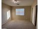Bright bedroom with large window, plush carpeting, and sliding door closet at 12733 W Boca Raton Rd, El Mirage, AZ 85335