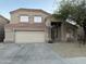 Two-story home featuring a two-car garage, desert landscaping, and a tree in the front yard at 12733 W Boca Raton Rd, El Mirage, AZ 85335