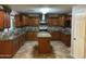 Spacious kitchen features wood cabinets, granite countertops, stainless appliances and a center island at 12733 W Boca Raton Rd, El Mirage, AZ 85335