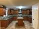 Spacious kitchen with dark wood cabinets, a center island, and stainless steel appliances at 12733 W Boca Raton Rd, El Mirage, AZ 85335