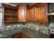 Close-up of kitchen with granite countertops, tile backsplash, and dark wood cabinets at 12733 W Boca Raton Rd, El Mirage, AZ 85335