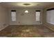 Spacious living room with tile flooring, two windows and a hanging light fixture at 12733 W Boca Raton Rd, El Mirage, AZ 85335