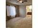 Cozy living room featuring neutral walls, plush carpeting, and a ceiling fan for added comfort at 12733 W Boca Raton Rd, El Mirage, AZ 85335