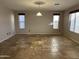 Spacious living room with tile flooring, two windows and a hanging light fixture at 12733 W Boca Raton Rd, El Mirage, AZ 85335