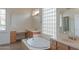 Bright bathroom features a soaking tub, vanity, and plenty of natural light at 13417 W La Vina Dr, Sun City West, AZ 85375