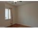 Cozy bedroom featuring hardwood floors, a window with shutters, and neutral curtains for privacy at 13417 W La Vina Dr, Sun City West, AZ 85375