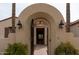 Arched entryway with an iron gate and sconces that leads into the home at 13417 W La Vina Dr, Sun City West, AZ 85375