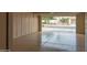 Open garage with painted floor and lots of storage cabinets; view of front yard and neighborhood at 13417 W La Vina Dr, Sun City West, AZ 85375