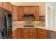 Well-lit kitchen features wooden cabinetry, tile backsplash, and sleek countertops at 13417 W La Vina Dr, Sun City West, AZ 85375