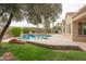 Backyard pool and spa featuring lush landscaping and travertine patio at 13417 W La Vina Dr, Sun City West, AZ 85375