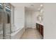 Well-lit bathroom featuring a soaking tub, tiled floor, and double vanity at 13803 W Calle De Baca --, Peoria, AZ 85383