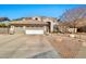 Charming stucco home featuring a three-car garage, desert landscaping and a tile roof at 1554 E Stirrup Ct, Gilbert, AZ 85296