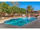 Backyard pool with outdoor kitchen, hot tub, and mature trees at 1554 E Stirrup Ct, Gilbert, AZ 85296