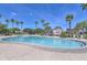 Large community pool surrounded by palm trees, lounge chairs and shade structures at 17131 W Oberlin Way, Surprise, AZ 85387