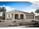 Charming single-story home showcasing a desert landscape, arched entryway, and attached two car garage at 17422 W Via Dona Rd, Surprise, AZ 85387