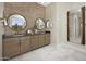 Elegant bathroom with double vanities, round mirrors, and neutral tones creating a relaxing atmosphere at 17434 W Via Dona Rd, Surprise, AZ 85387