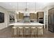 Modern kitchen featuring a large island with seating, stainless steel appliances, and stylish pendant lighting at 17434 W Via Dona Rd, Surprise, AZ 85387