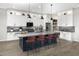 Modern kitchen featuring a large island with seating, stylish countertops, and ample white cabinetry at 17450 W Via Dona Rd, Surprise, AZ 85387