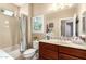 Traditional bathroom featuring a shower-tub combo, patterned tile accents, and a wood vanity at 1822 N 164Th Dr # 58, Goodyear, AZ 85395
