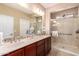 Bright bathroom featuring double sinks, granite countertops, and a glass enclosed shower at 1822 N 164Th Dr # 58, Goodyear, AZ 85395