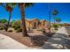 Suburban home featuring desert landscaping, palm trees, flowering bushes, and a spacious three-car garage at 1822 N 164Th Dr # 58, Goodyear, AZ 85395