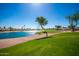 Picturesque golf course view with a serene lake, lush green grass, and clear blue sky, offering a tranquil escape at 1822 N 164Th Dr # 58, Goodyear, AZ 85395