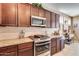 Gourmet kitchen with stainless steel appliances, granite countertops, and dark wood cabinets at 1822 N 164Th Dr # 58, Goodyear, AZ 85395